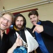 Applying a Sling During First Aid Workshop Three men indoors are smiling. The man in the middle has his arm in a sling, while one man gives a thumbs up and the man on the right points at him. They all look cheerful and friendly after their outdoor first aid workshop in Utrecht.Experience the adventure and learn life-saving skills during our outdoor first aid workshop! Sign up now for a unique experience full of action and fun in Utrecht.