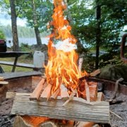 Join our exciting fire-making workshop and master the art of creating the perfect campfire! Set in a picturesque location with lush green trees and a tranquil lake, you'll learn to build a roaring fire using wooden planks and kindling. Ideal for adventurers seeking an unforgettable outdoor experience. Book your spot today!   