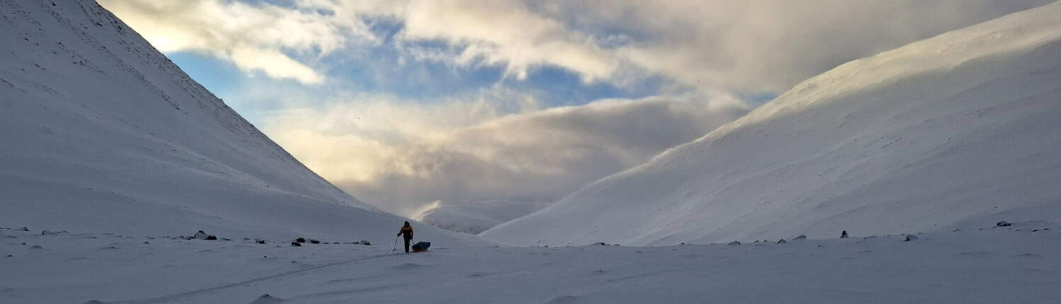 Trek met een slee door de uitgestrekte, besneeuwde valleien van Zweeds Lapland tijdens een winterse beklimming van de Kebnekaise. Beleef een avontuurlijke expeditie langs eindeloze bergen en indrukwekkende luchten – het ultieme avontuur voor echte natuurliefhebbers!.
