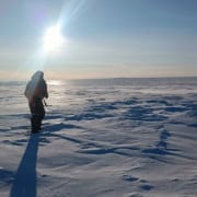 groenland15 Wandelaar in de sneeuw onder de zon in Arctic Adventure outdoor workshop.