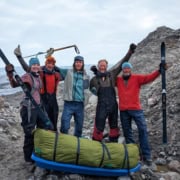 Rondreizende wandelaars op ruige kustlijn met rotsen en zee, klaar voor outdoor avontuur.
