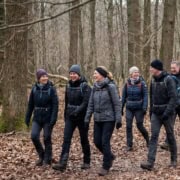 People hiking in a forest in autumn, dressed in outdoor clothing and having fun.