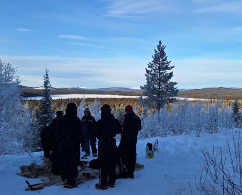 Outdoor workshop in snowy landscape with a group of people.