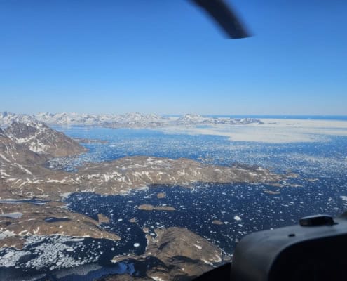 Gletsjerlandschap met ijsbergen en bergen in de Arctische regio, gezien vanuit een vliegtuig.