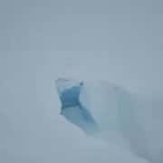Iceberg in snowstorm with heavy wind and snowflakes.