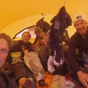 Veilig binnen de tent tijdens de Groenland-expeditie met teamleden en uitrusting.