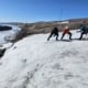 Three people pulling pulks across the Greenland ice plain during an expedition.