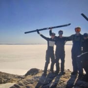 Gezelschap van vier mensen met ski-uitrusting op een bevroren meer, genieten van een winterse outdoo.